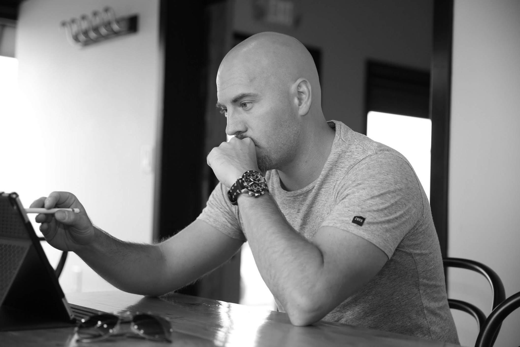 Black-and-white photograph of Liam Legault working at a laptop.