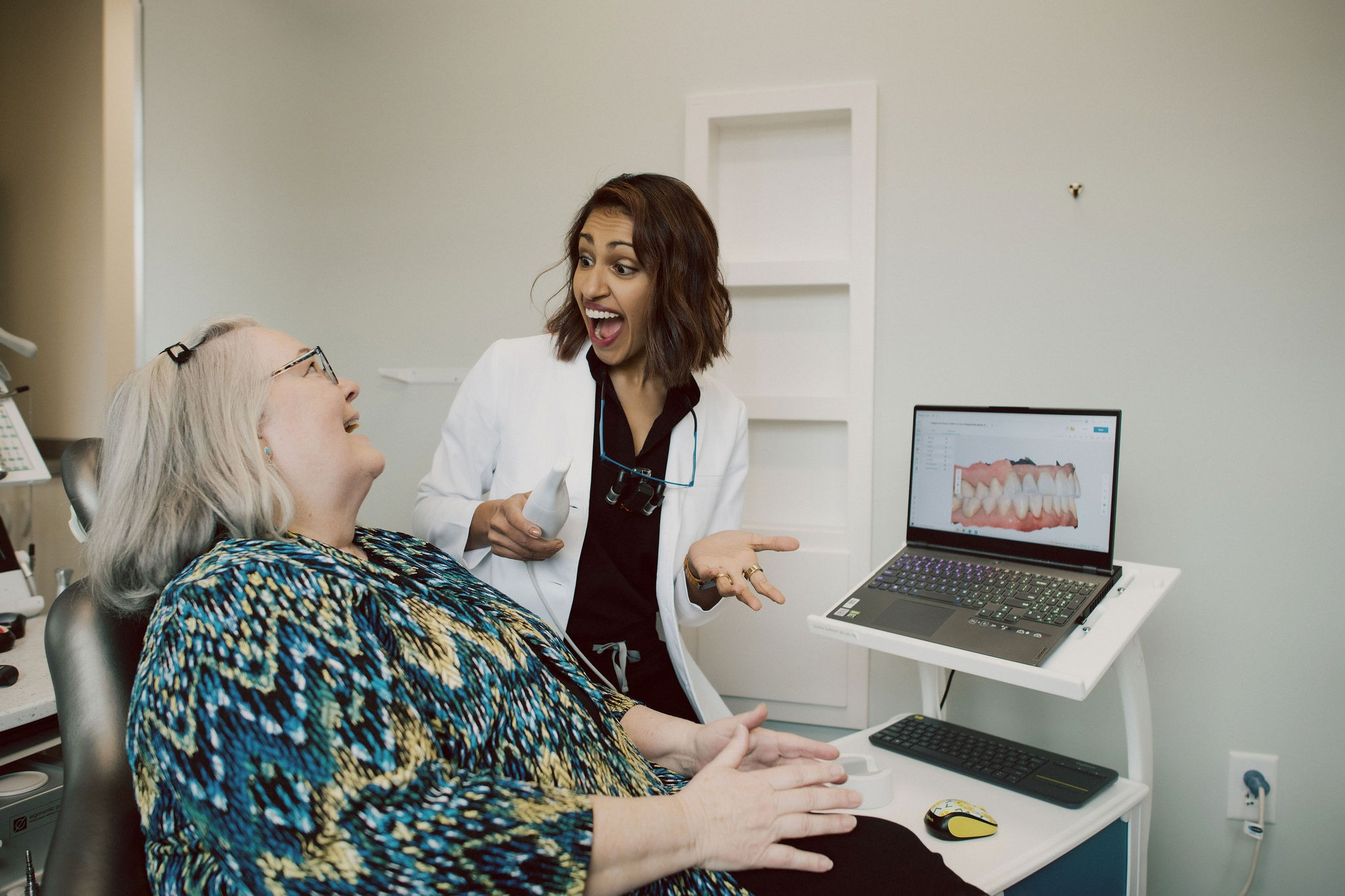 A healthcare professional engages joyfully with a patient during a dental consultation session