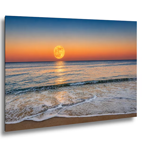 Sunset over the ocean with a large moon reflecting on the water's surface