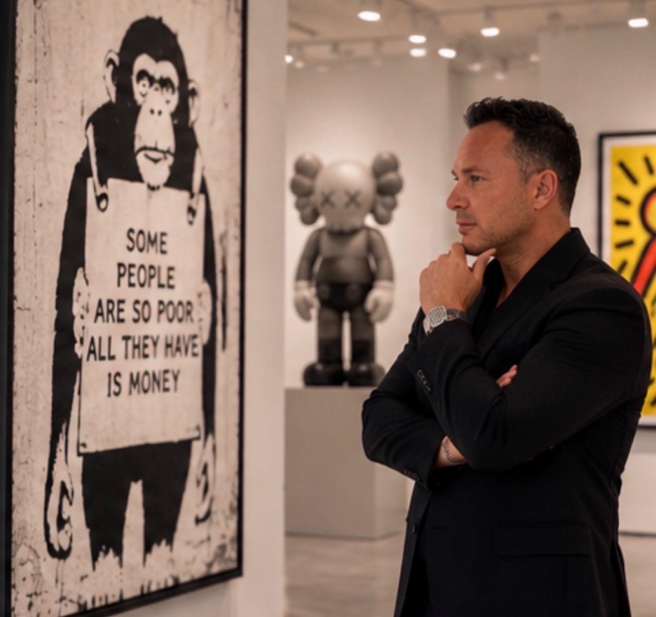 A man in a suit observes art in a contemporary gallery setting