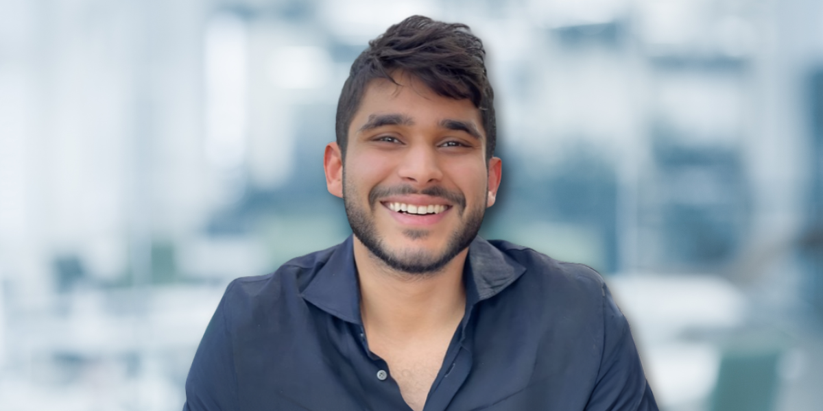 Smiling young man with tousled hair in a blurred office background