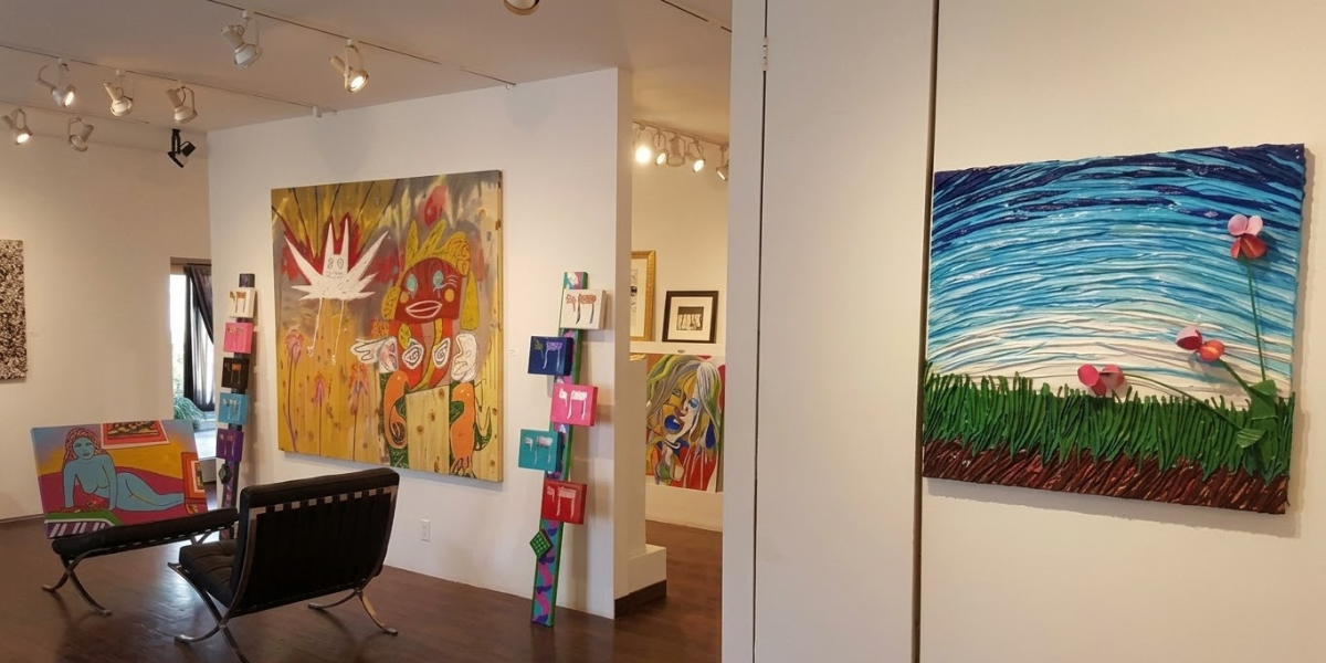 Art gallery interior showcasing colorful paintings and a modern seating area