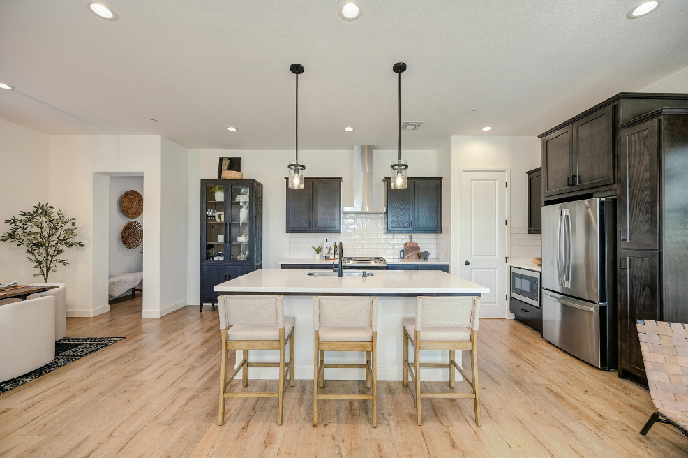 Modern kitchen featuring an island, dark cabinetry, and stylish pendant lighting.