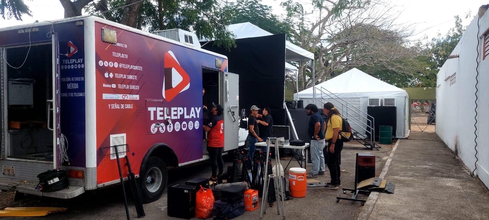 Teleplay production truck with crew setting up equipment outdoors at an event