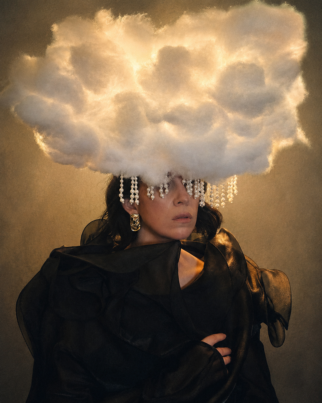 A woman wears a cloud-shaped headpiece adorned with beads, dressed in a dark, ruffled outfit
