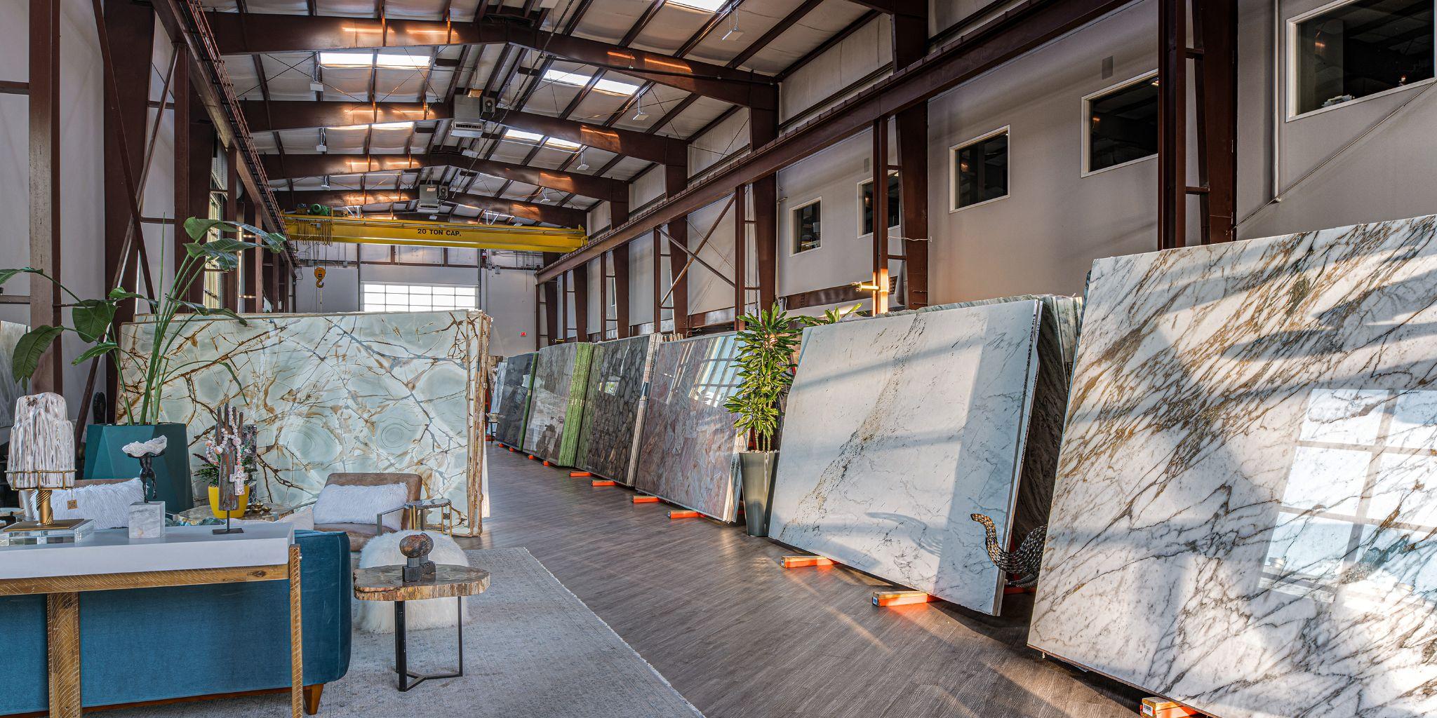 Interior of a showroom displaying various large stone slabs along a spacious hallway