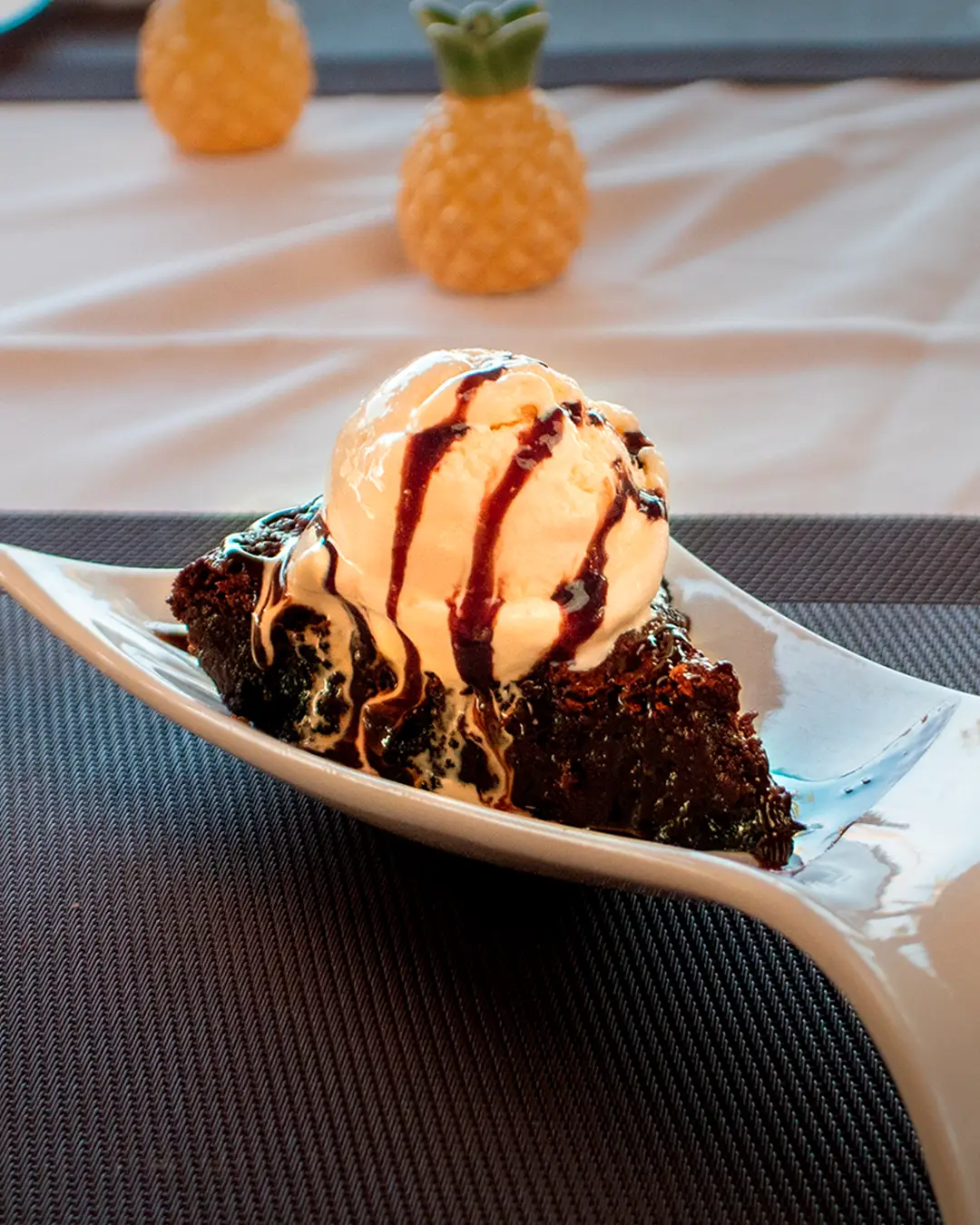 Chocolate dessert topped with vanilla ice cream and drizzled with chocolate sauce