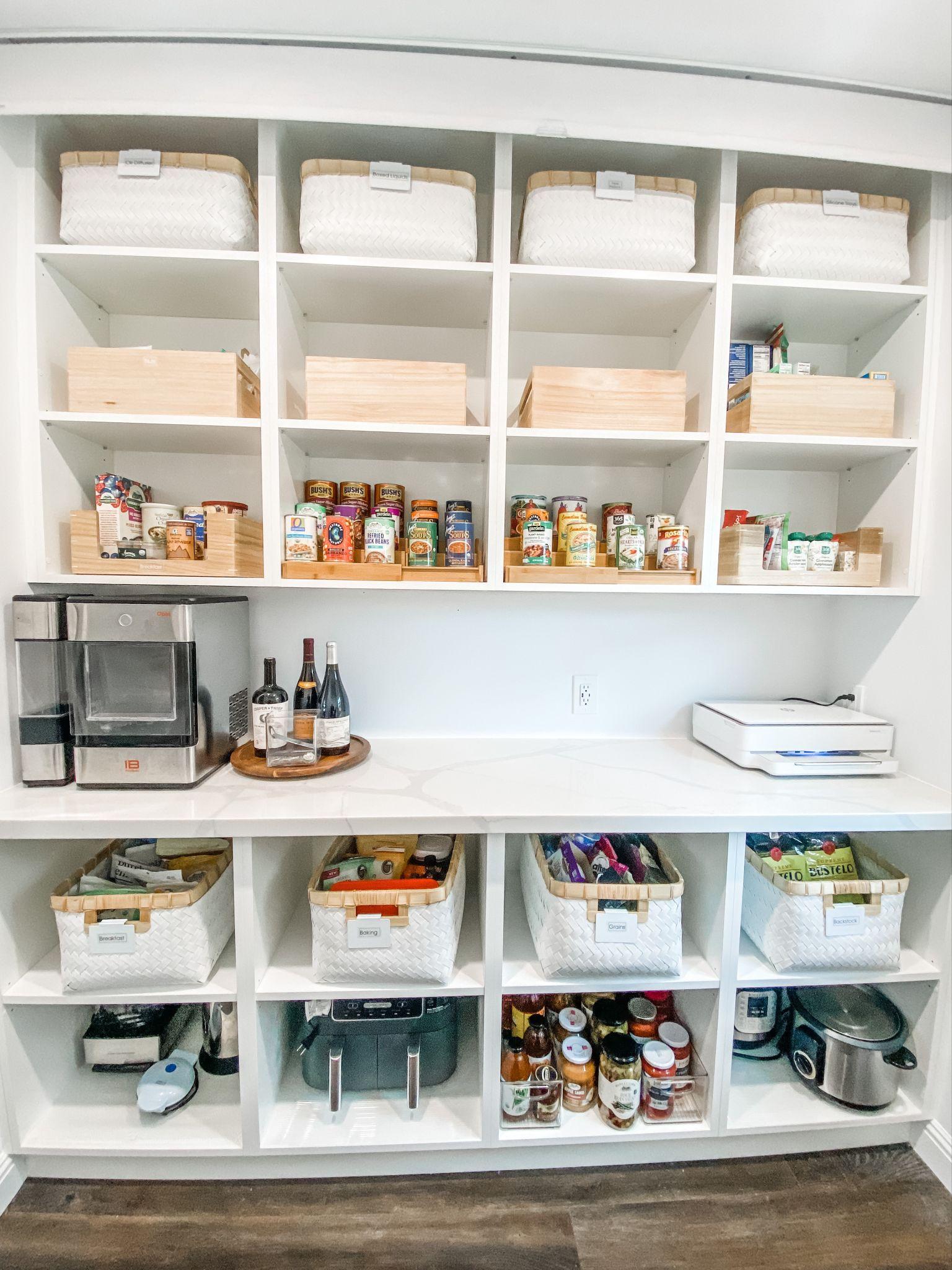 Organized pantry with shelves containing various containers, jars, and kitchen appliances