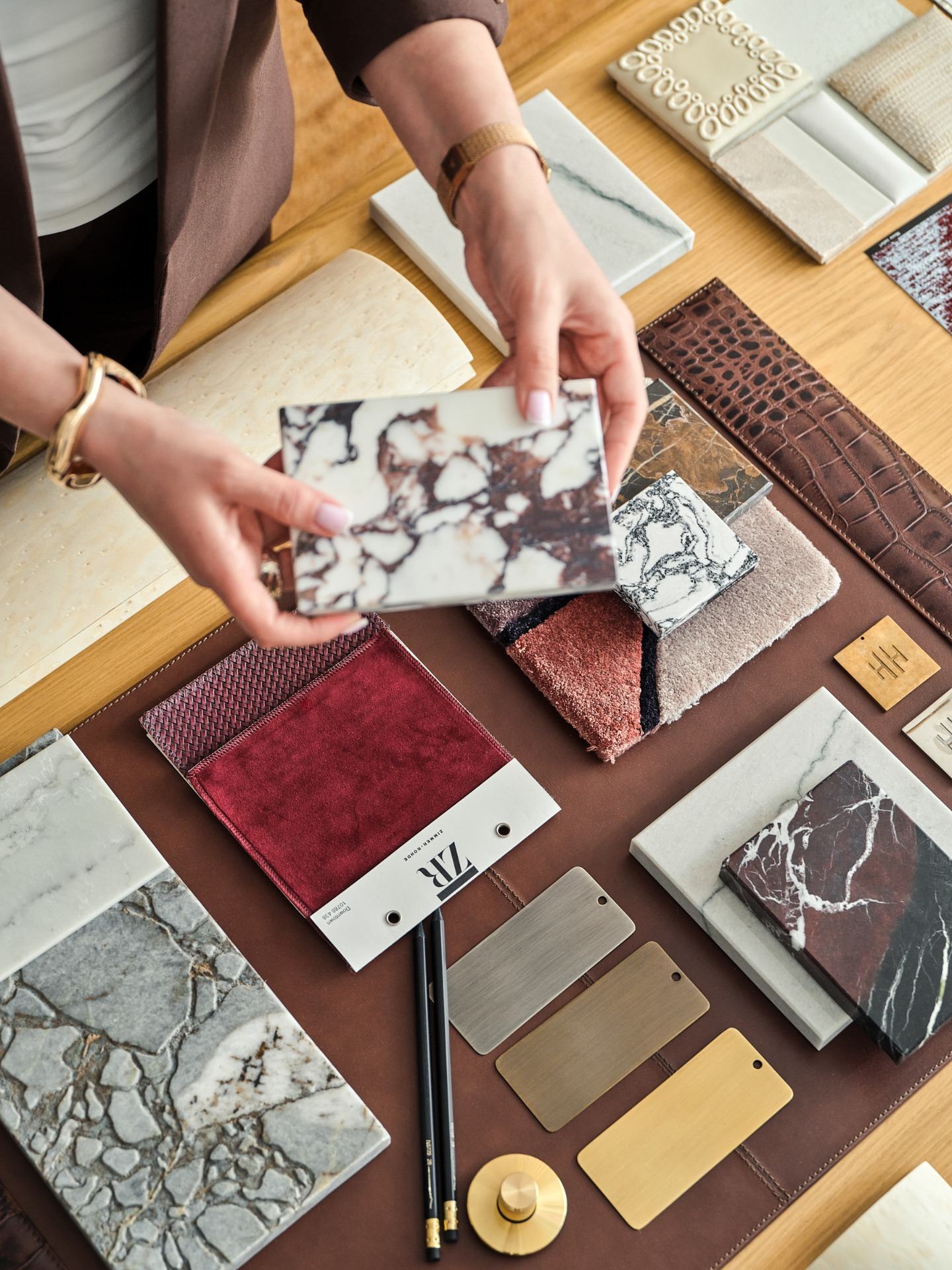 Person selecting marble samples from a variety of textured materials and color swatches.