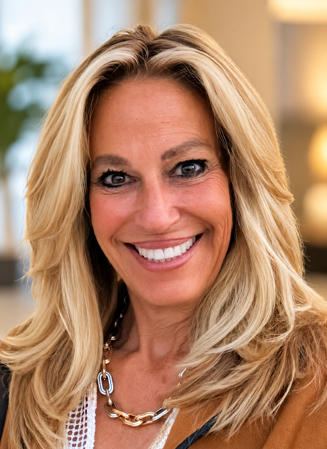Woman with long blonde hair smiling in a well-lit indoor setting