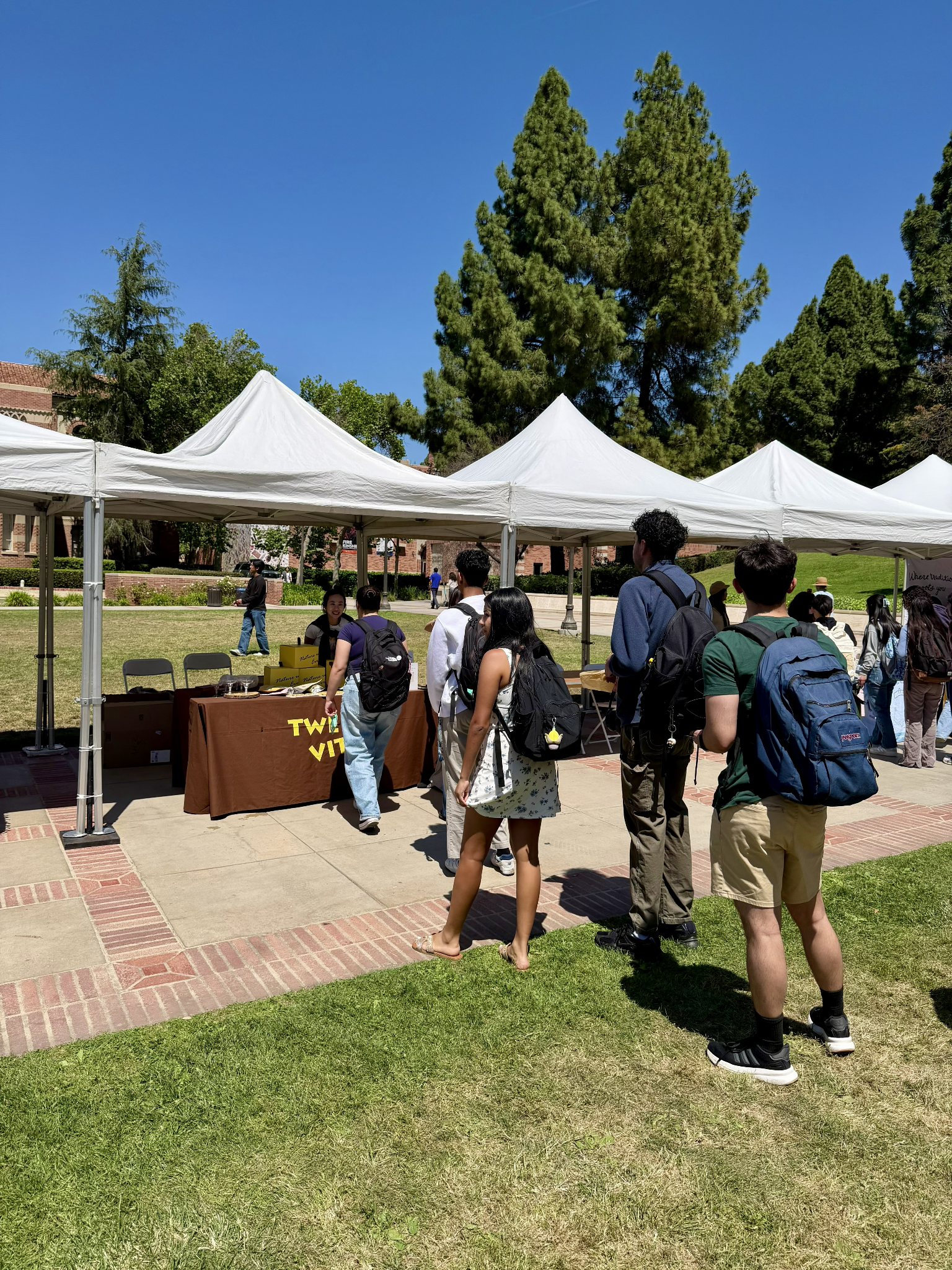 Outdoor event with tents, people in line, and a table labeled "Twilight Zone"