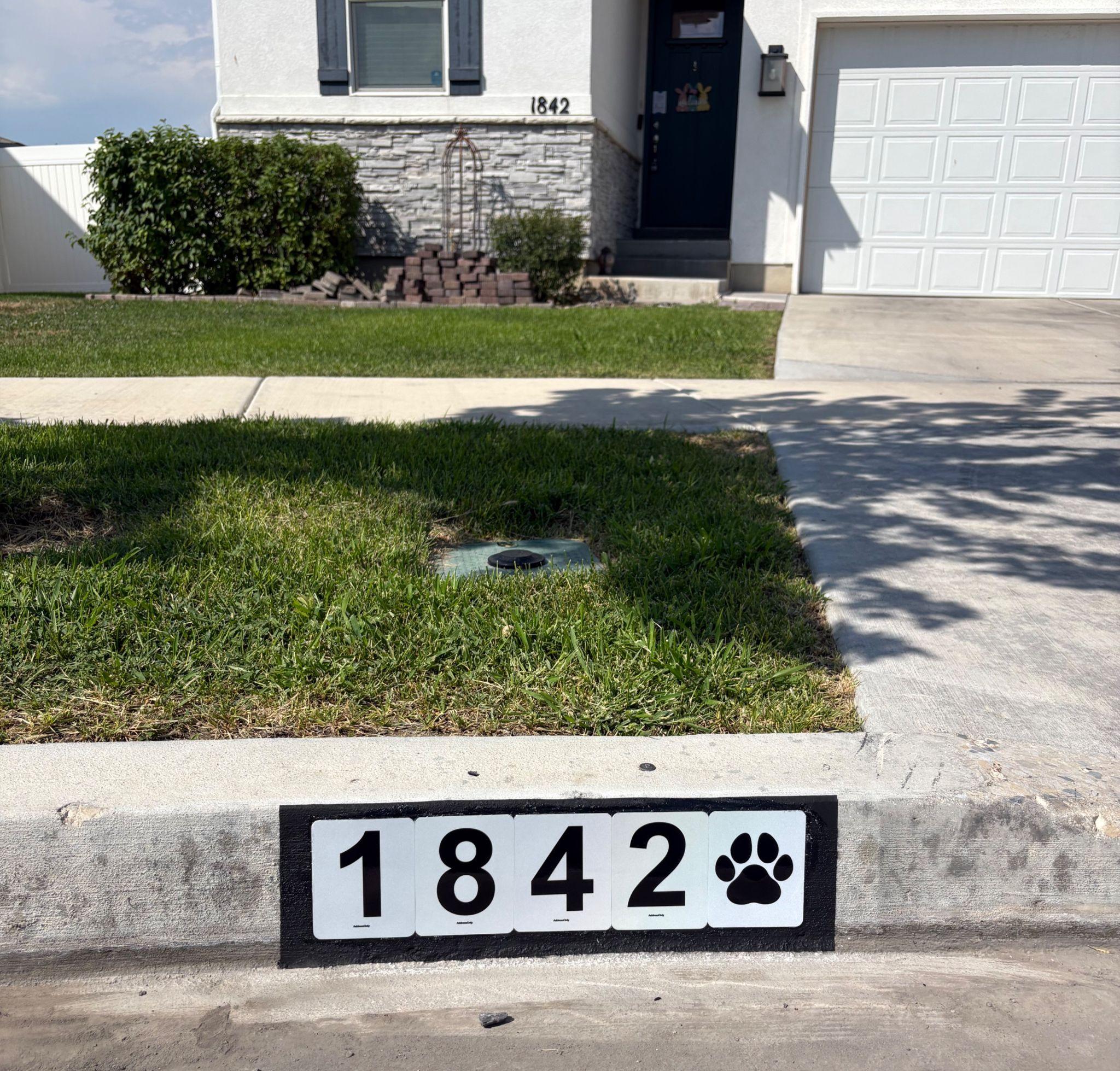 Street view of a house showing the address 1842 with a paw print design