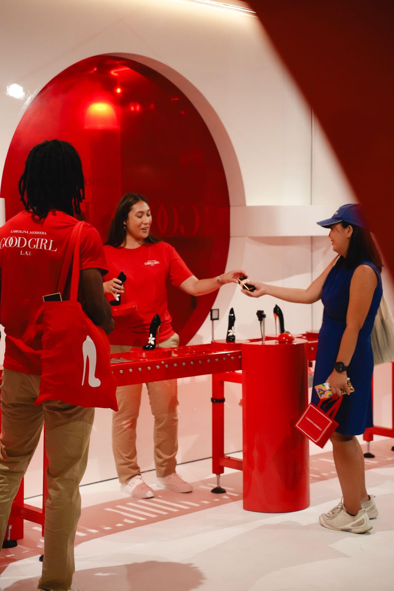 A red-themed event with a female attendant, customers interacting, and stylish displays.