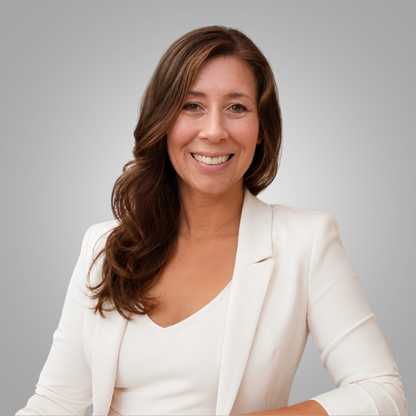 Smiling woman in a white blazer against a gray background