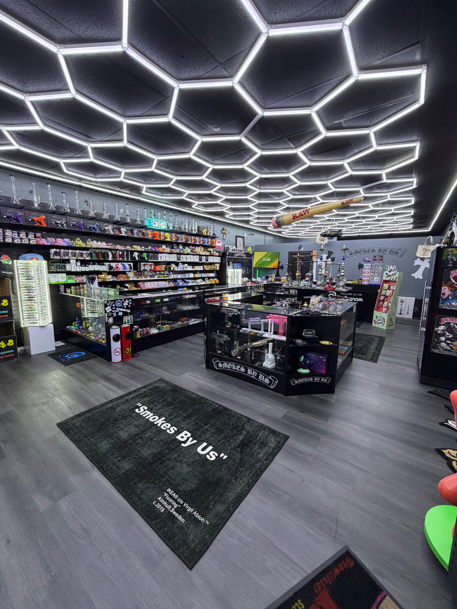Interior of a modern smoke shop with colorful displays and hexagonal ceiling lights