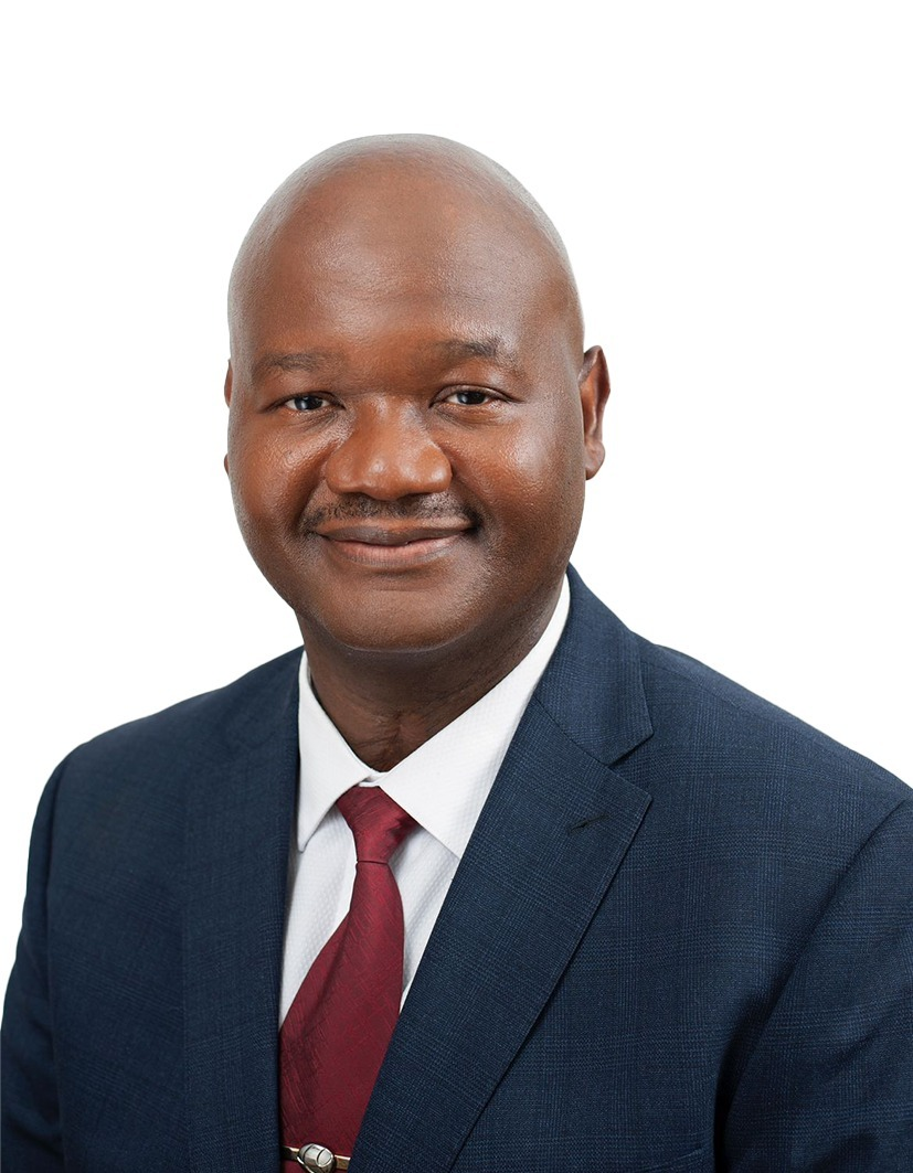 Smiling man in a dark suit with a white shirt and burgundy tie