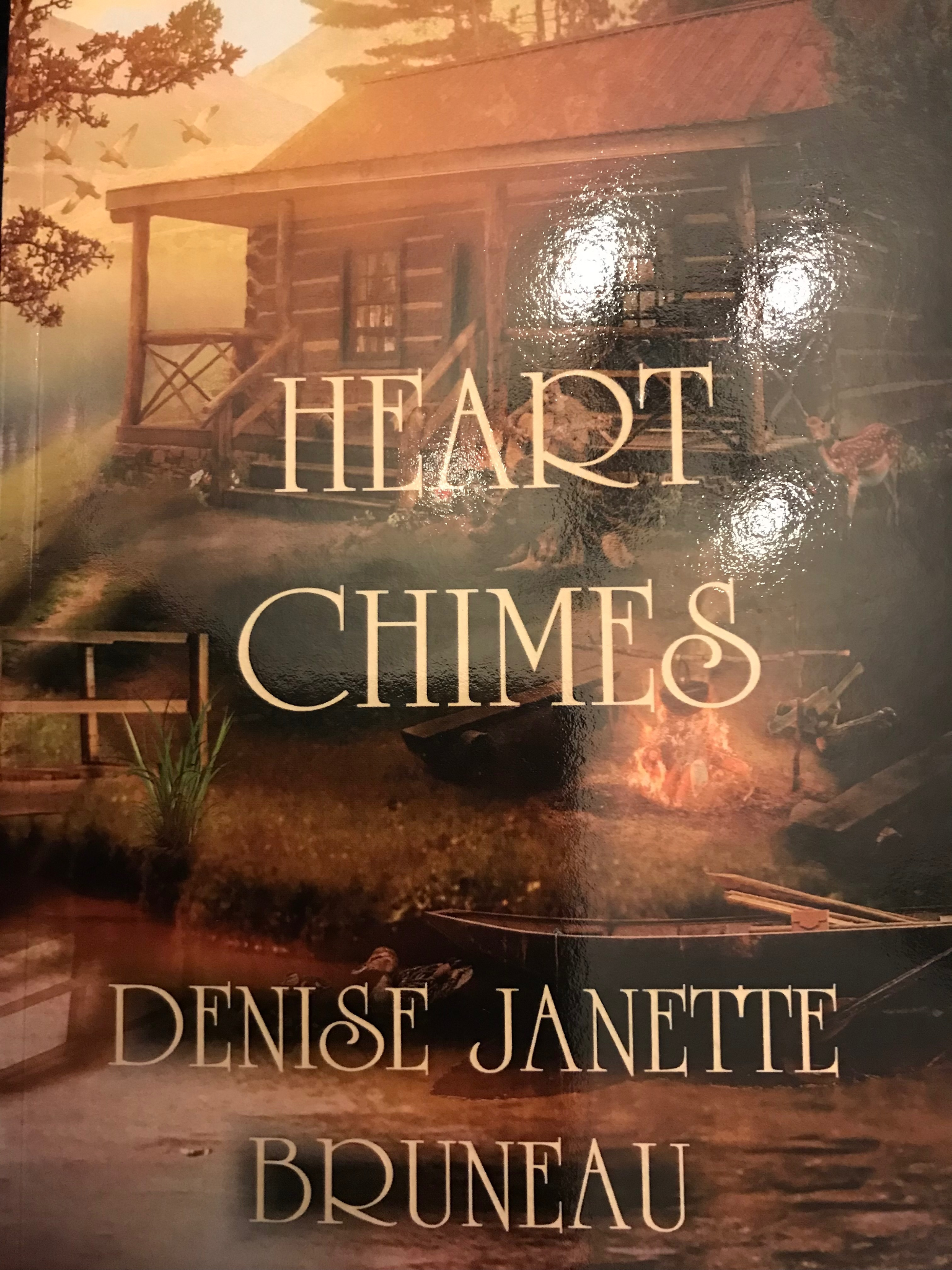 Book cover of "Heart Chimes" by Denise Janette Bruneau featuring a rustic cabin scene