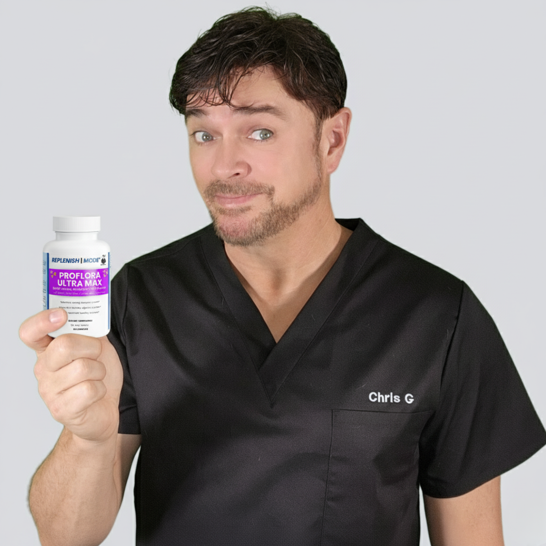 A man in scrubs holds a supplement bottle, smiling at the camera
