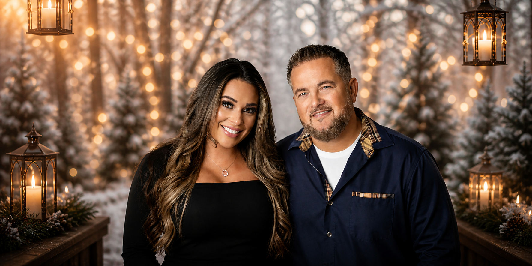 Smiling couple posing in winter setting with festive lights and lantern decorations