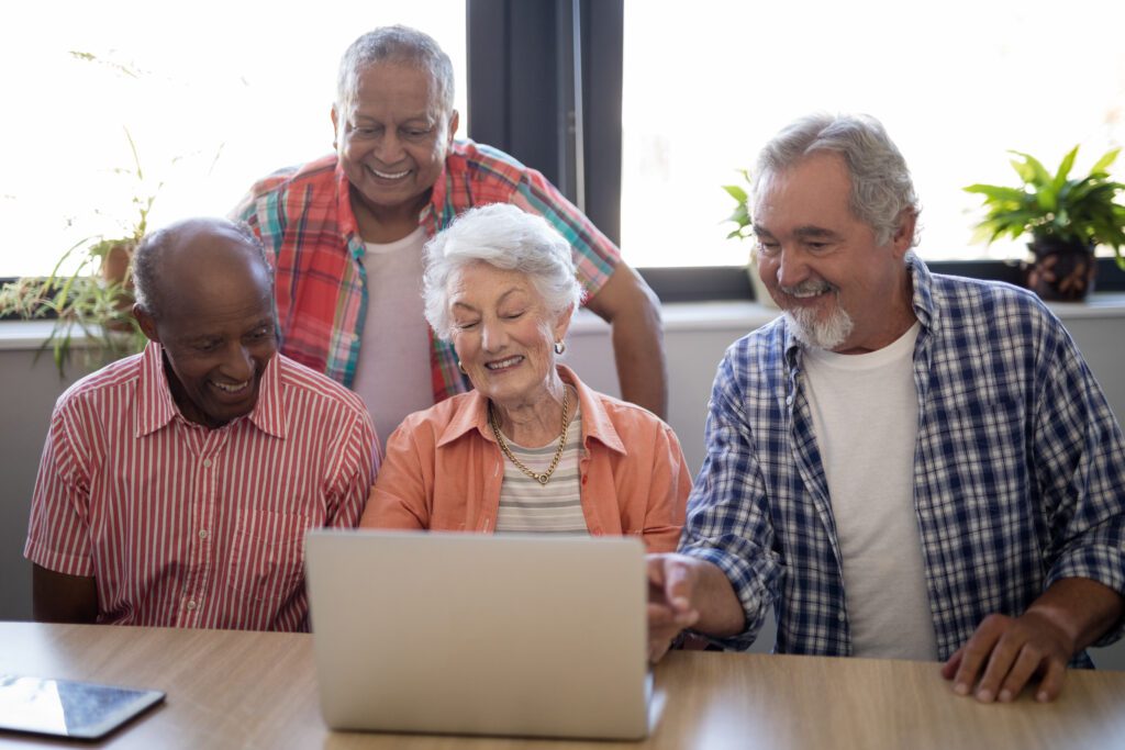 happy-senior-people-using-laptop-at-table-2023-11-27-05-12-24-utc1-1024x683-1.jpg